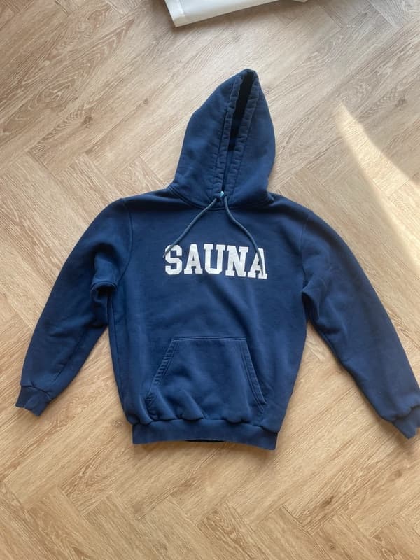 Blå Sauna hoodie på et trægulv
